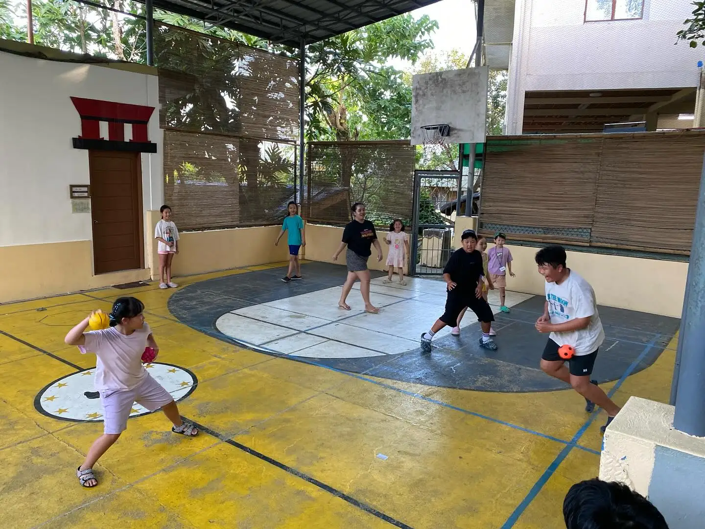 Children playing dodgeball on the school court